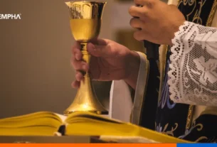 Celebración de eucaristía transmitida en línea, con cáliz, hostia y Biblia sobre un altar iluminado.